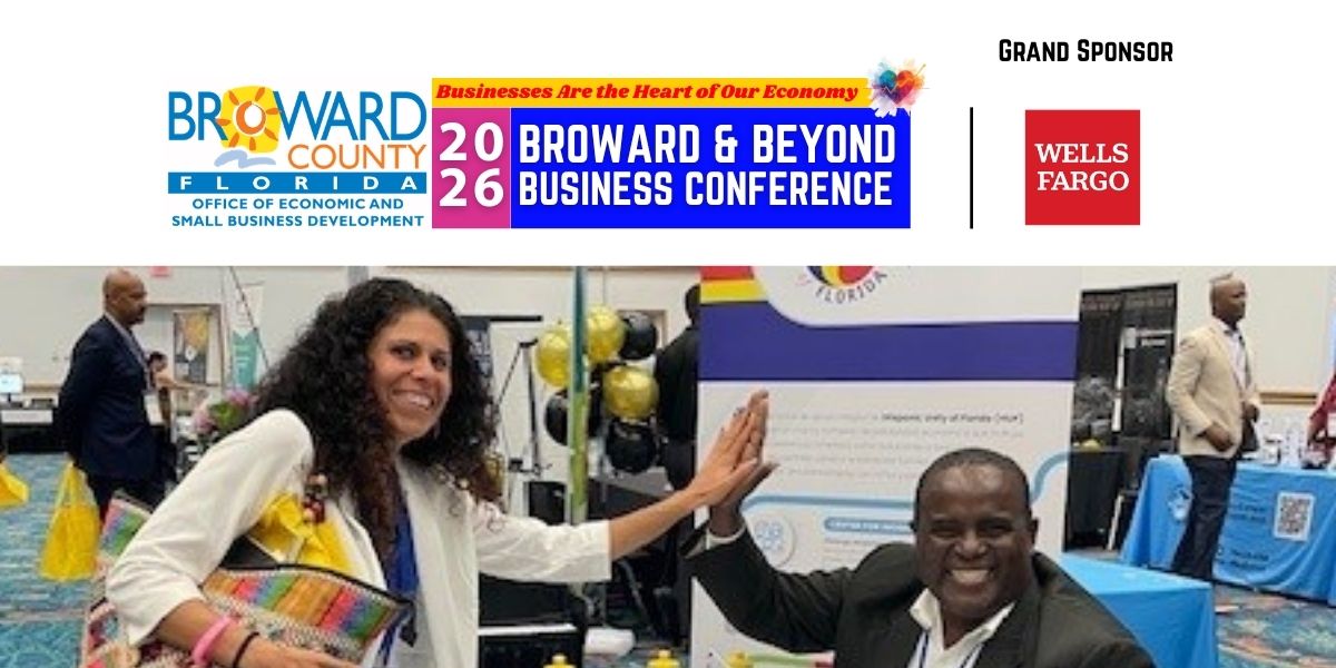 Two people high five in an exhibit hall below conference banner