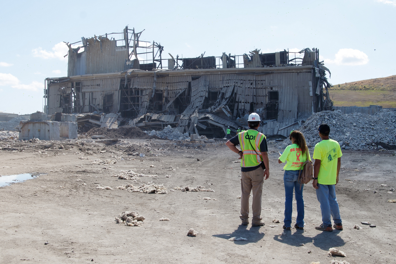 Dynamic Compaction Permits - Three Workers looking towards a demolished building. 