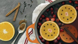 cranberries, oranges and cinnamons in a pot of water