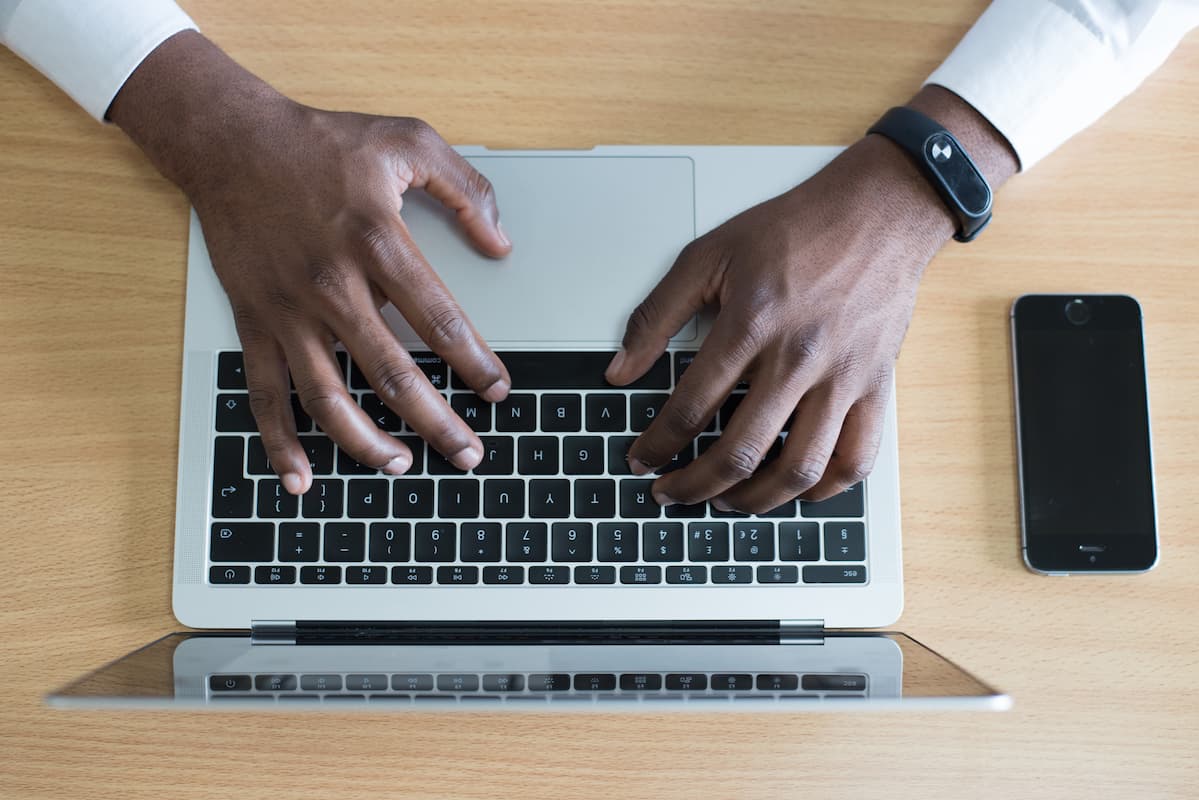 Hands typing on laptop