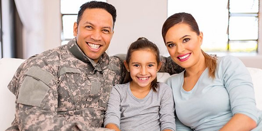 father in fatigues with wife and daughter