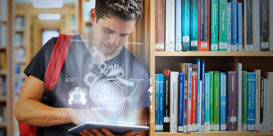 young man in library using digital tablet