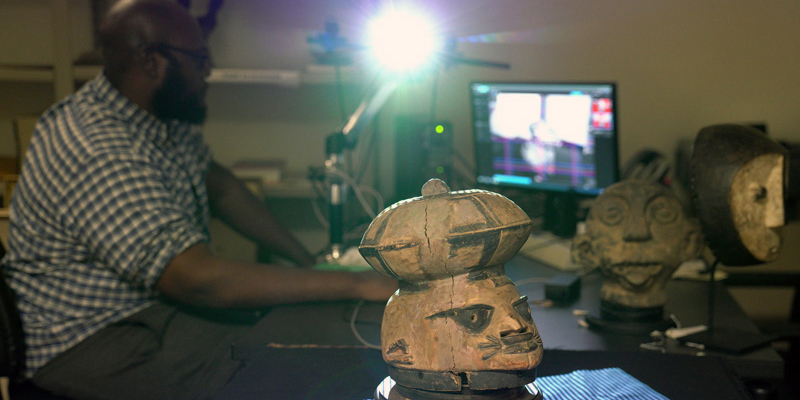male librarian scanning African artifacts