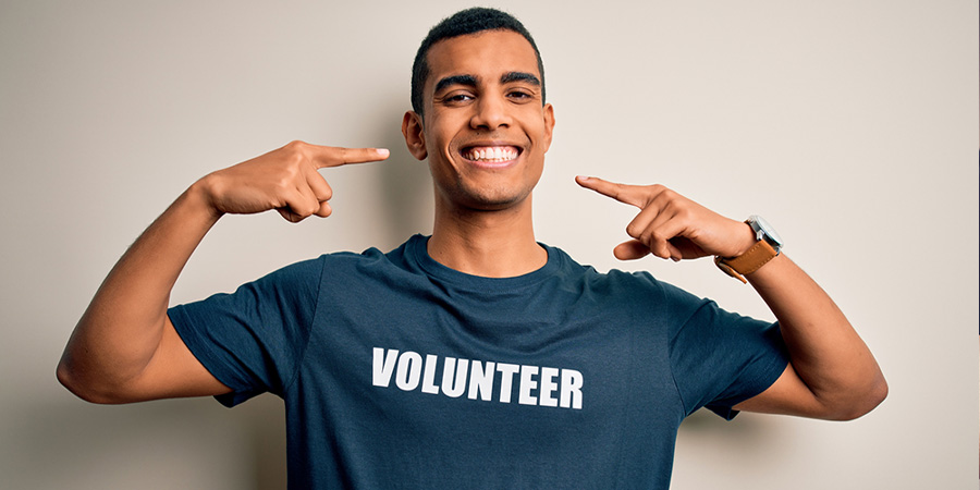 happy young man wearing volunteer shirt